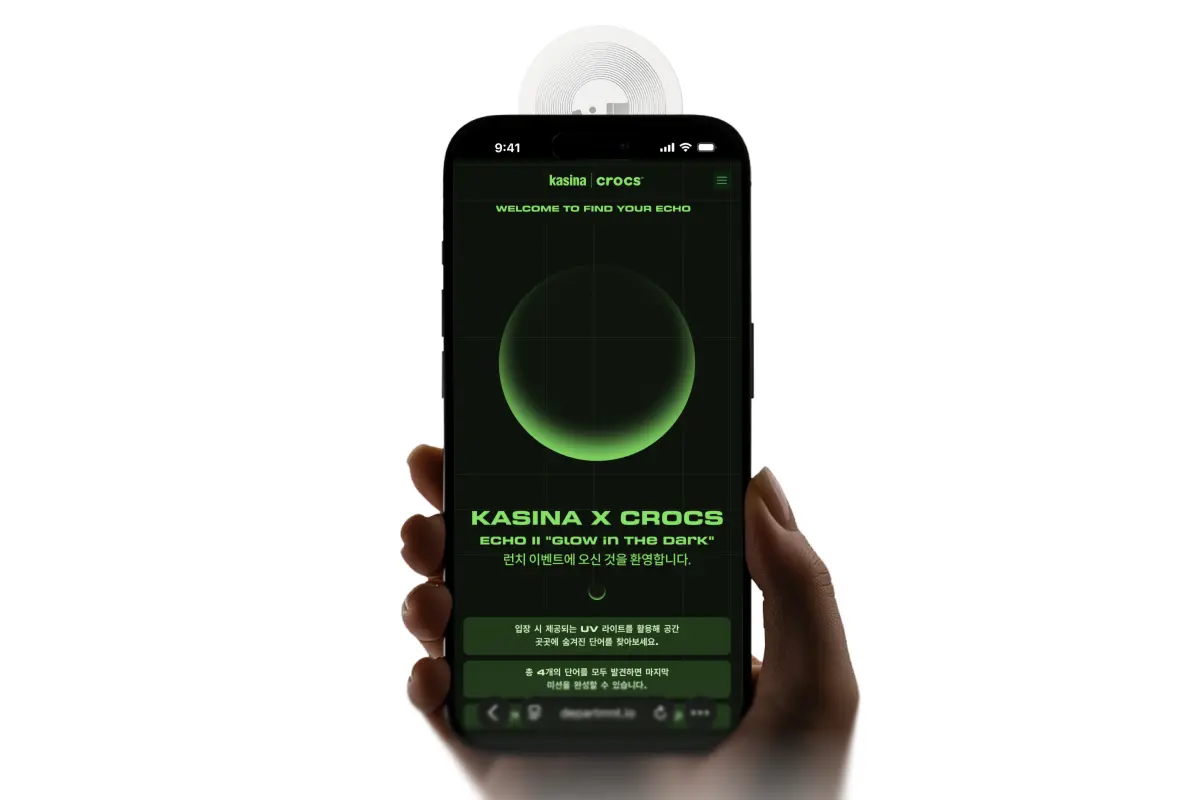 Render: a phone held under a tag, the Kasina × Crocs Portal open on screen